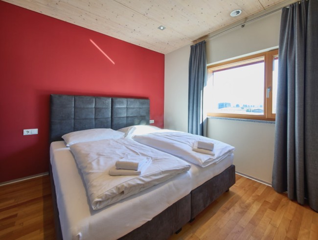 Gemütliches Bett in modernem, hellen Schlafzimmer