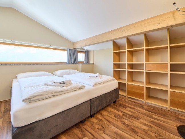 Gemütliches Doppelbett mit viel Stauraum im hellen Schlafzimmer