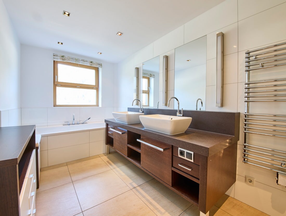 Modernes Badezimmer mit Badewanne, Doppelwaschbecken und Handtuchheizkörper